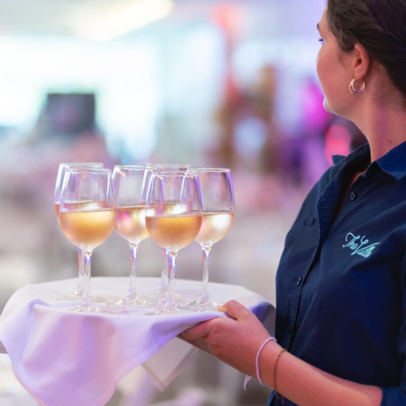 A staff member serving drinks on a tray